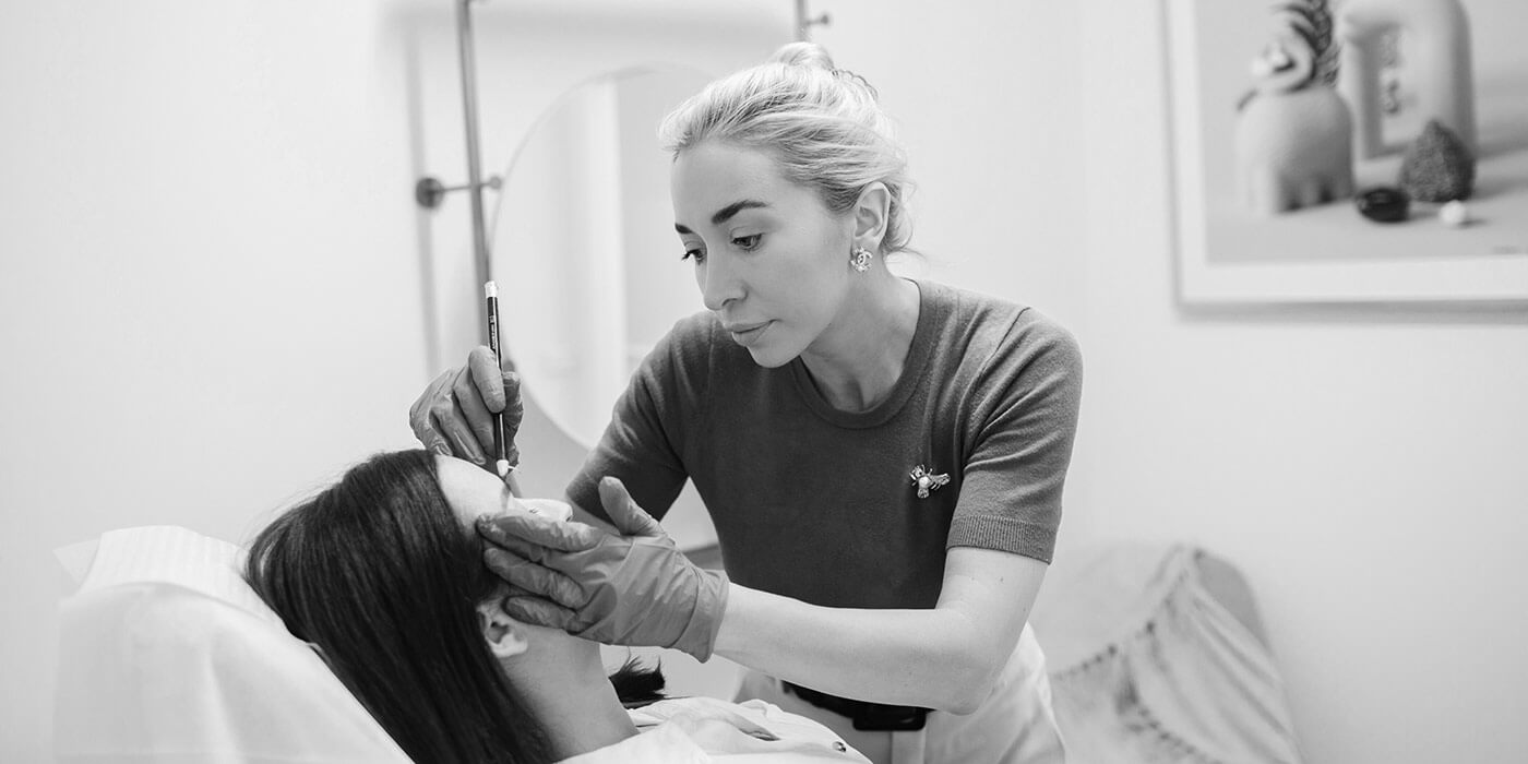 Claire Martinez making eyebrow measurements for micropigmentation on a client.