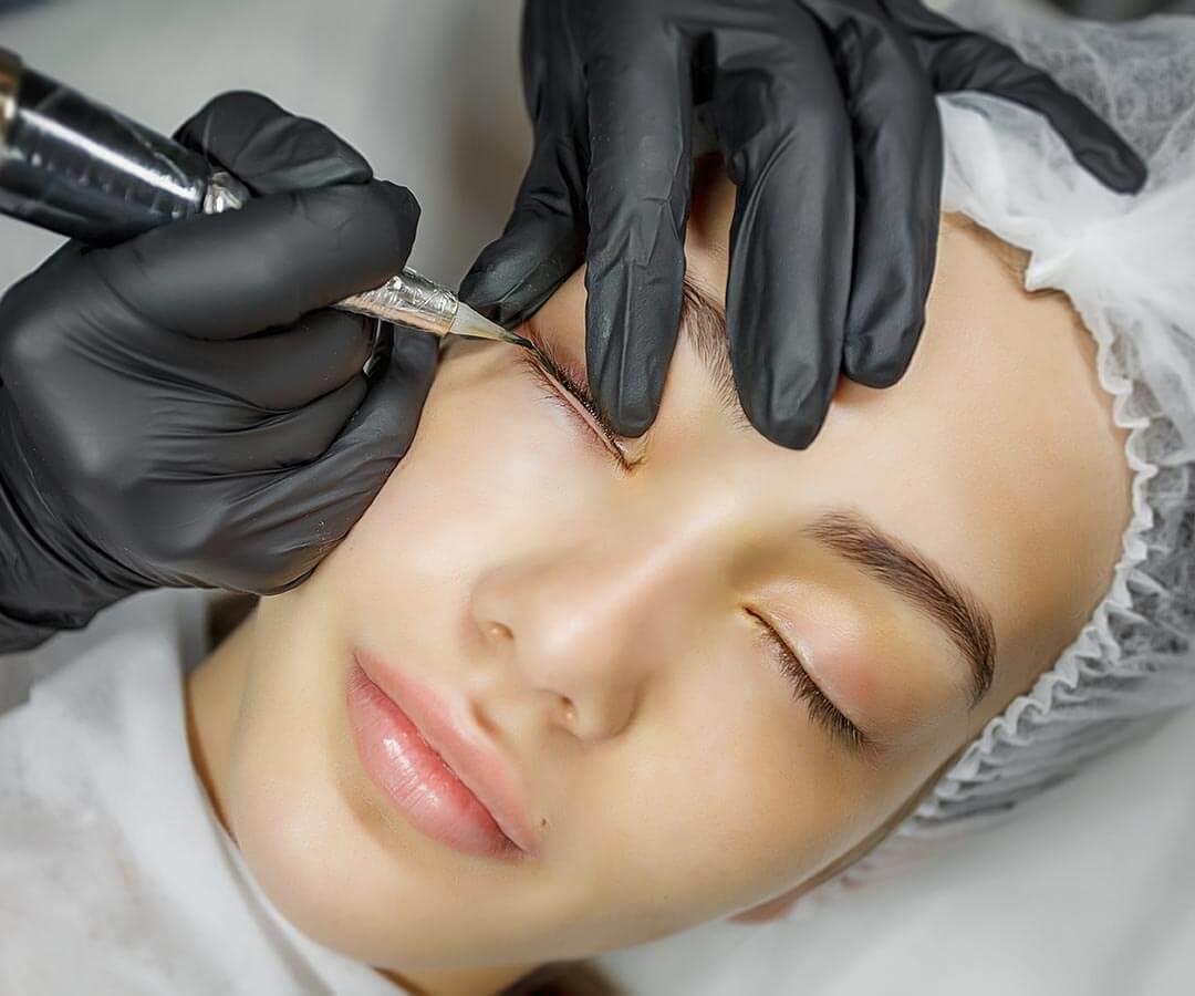 Woman having cosmetic eye tattooing for semi-permanent eye makeup effect.